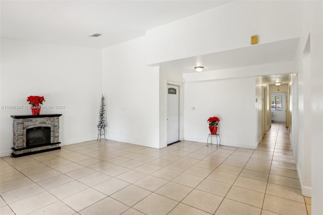 unfurnished living room with light tile patterned floors and a fireplace