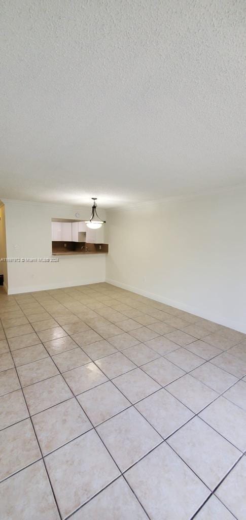 empty room featuring light tile patterned flooring and a textured ceiling