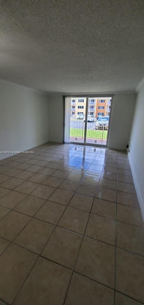 tiled spare room featuring a textured ceiling