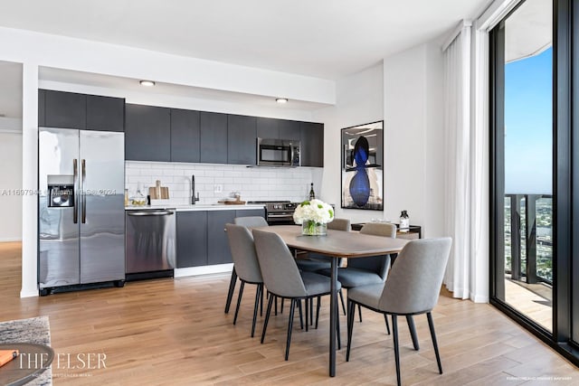 dining room featuring plenty of natural light, sink, and light hardwood / wood-style flooring