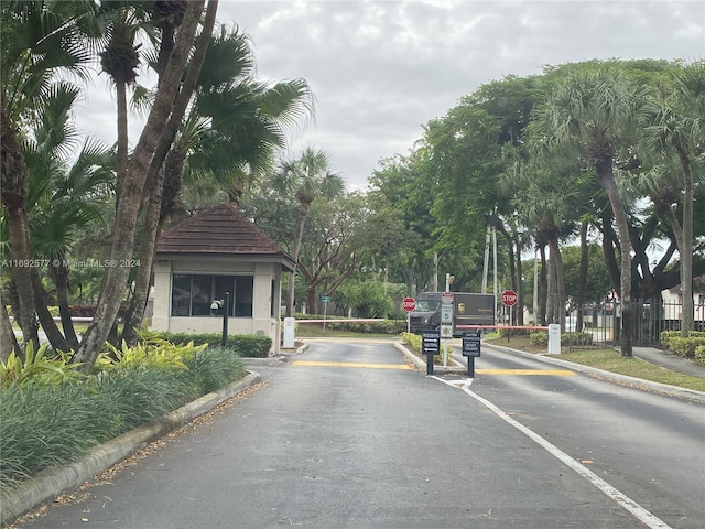 13380 SW 91st Ter Unit E, Miami, FL 33186 - view of asphalt road featuring traffic signs, curbs, and a gated entry