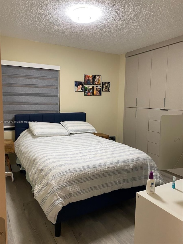 bedroom with hardwood / wood-style floors and a textured ceiling