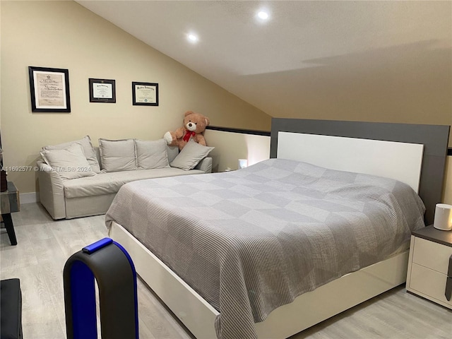 bedroom with vaulted ceiling and light hardwood / wood-style flooring