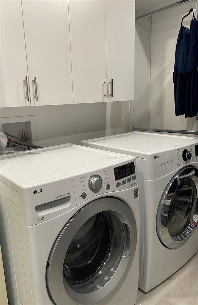 laundry room with cabinets, separate washer and dryer, and light hardwood / wood-style floors