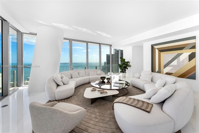 living room featuring plenty of natural light, floor to ceiling windows, and a water view