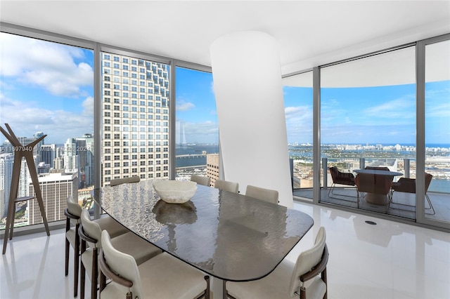 dining area featuring a water view and a wall of windows