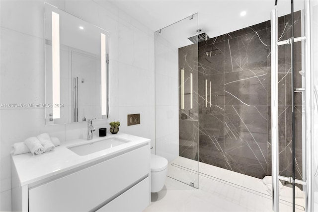 bathroom with a tile shower, vanity, and toilet