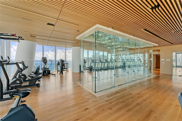 exercise room with a water view and light wood-type flooring