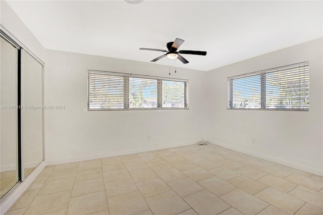 tiled empty room with ceiling fan