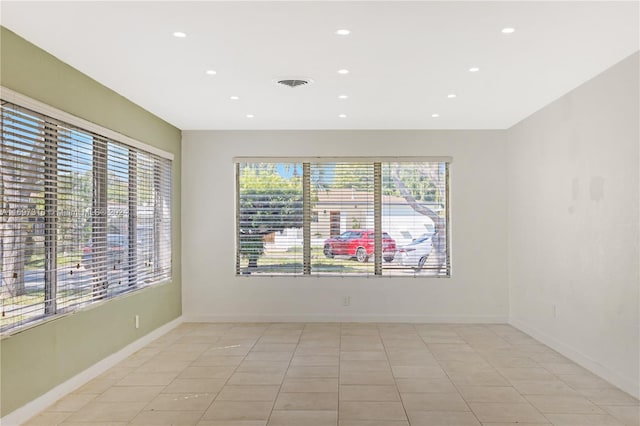 unfurnished room featuring plenty of natural light and light tile patterned floors