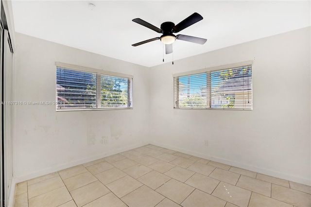 tiled spare room featuring ceiling fan