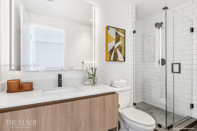 bathroom with an enclosed shower, vanity, and toilet