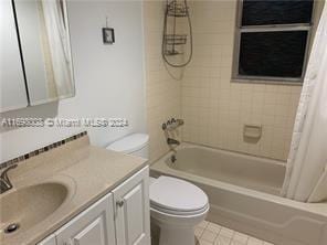 full bathroom featuring shower / tub combo, vanity, and toilet