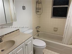 430 SE 2nd Ave Unit 3, Deerfield Beach, FL 33441 - full bathroom with toilet, vanity, shower / bath combination with curtain, and tile patterned floors
