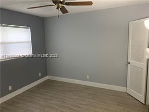 unfurnished room with ceiling fan and dark wood-type flooring