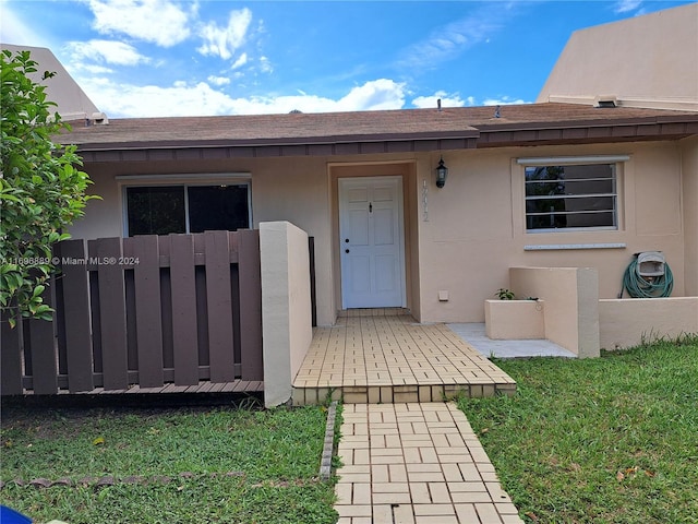 view of exterior entry with a lawn