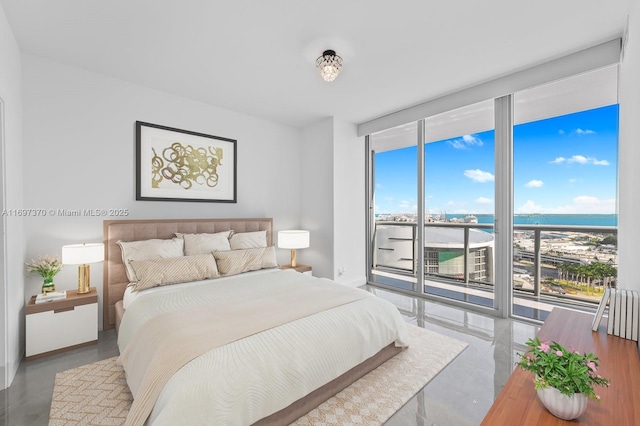 bedroom featuring a water view, floor to ceiling windows, and access to outside