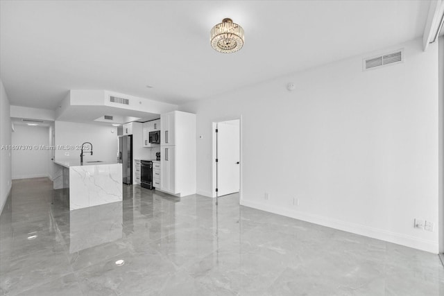 unfurnished living room featuring sink