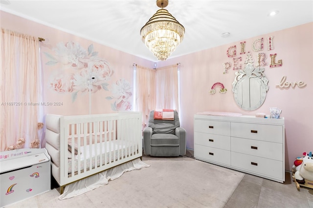 bedroom with a crib and a chandelier