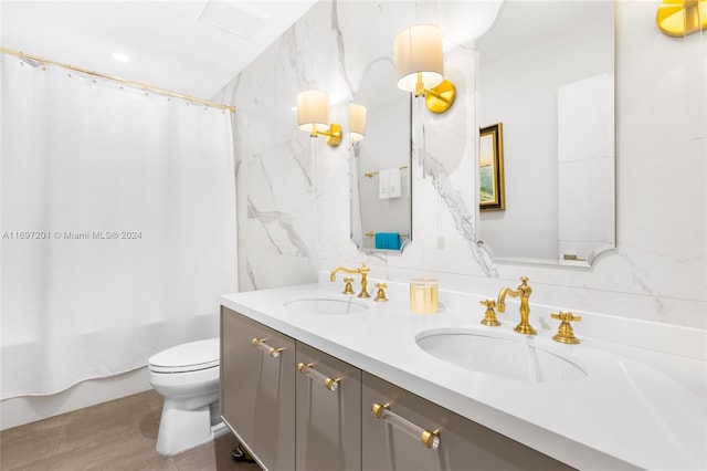 bathroom featuring vanity, toilet, and tile walls