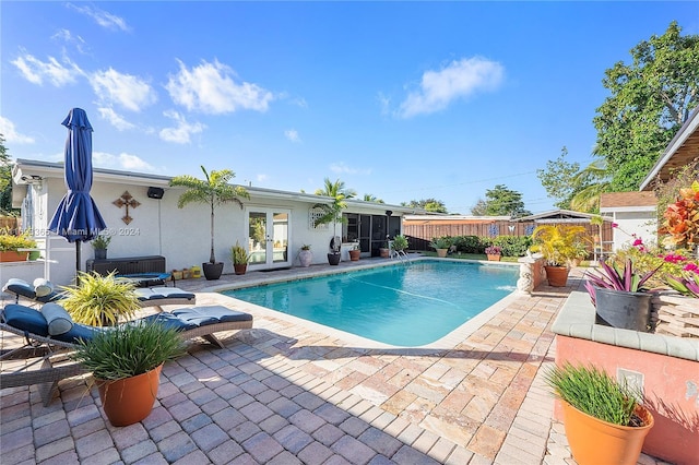 view of pool with french doors and a patio