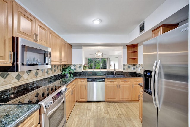 93 NE 17th Ct Unit 93, Fort Lauderdale, FL 33305 - kitchen with stainless steel appliances, tasteful backsplash, light wood finished floors, and dark stone counters