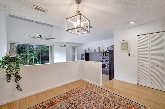 93 NE 17th Ct Unit 93, Fort Lauderdale, FL 33305 - hall featuring light wood-type flooring, a chandelier, and a textured ceiling