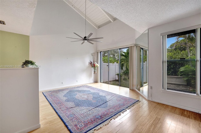 93 NE 17th Ct Unit 93, Fort Lauderdale, FL 33305 - unfurnished room featuring healthy amount of natural light, ceiling fan, wood finished floors, beam ceiling, and high vaulted ceiling