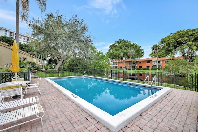 view of pool featuring a patio and a water view