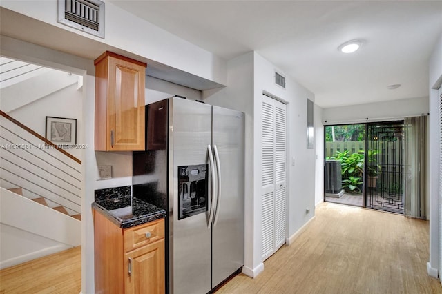 93 NE 17th Ct Unit 93, Fort Lauderdale, FL 33305 - kitchen with stainless steel fridge, light wood-type flooring, and dark stone countertops