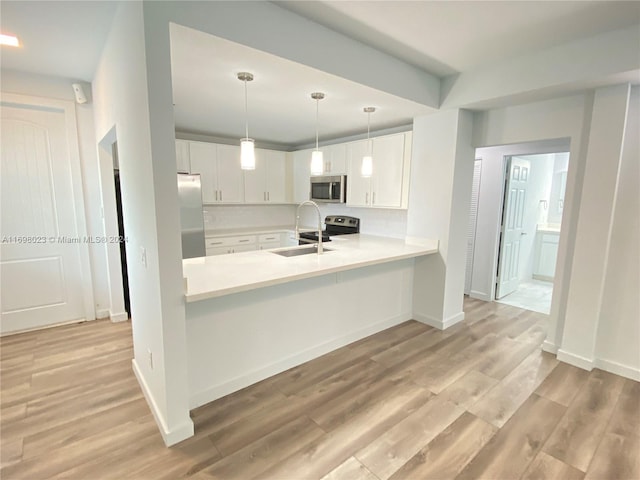 kitchen featuring white cabinets, sink, stainless steel appliances, and light hardwood / wood-style flooring