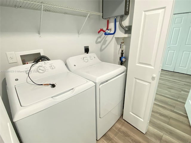 laundry room featuring water heater, wood-type flooring, and separate washer and dryer