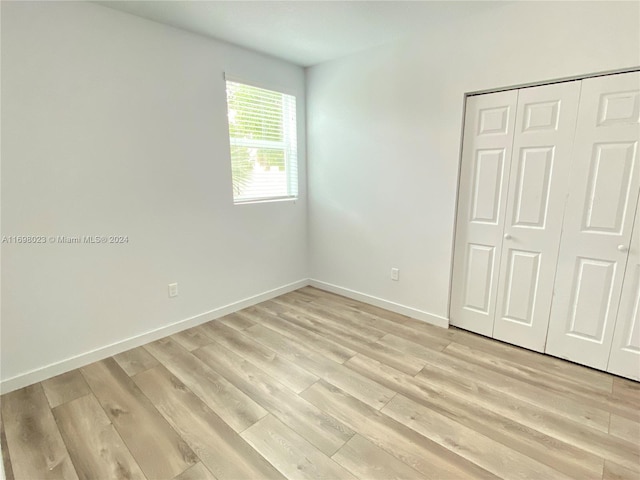 unfurnished bedroom with light hardwood / wood-style floors and a closet