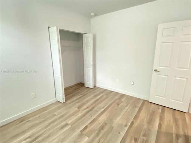 unfurnished bedroom with a closet and light hardwood / wood-style floors