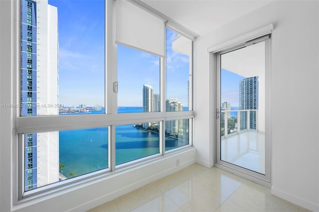 interior space featuring tile patterned flooring, plenty of natural light, and a water view