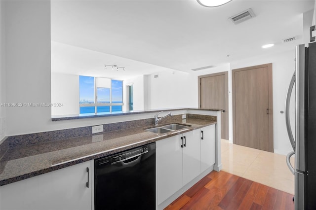 kitchen featuring dark hardwood / wood-style flooring, sink, dishwasher, white cabinetry, and stainless steel refrigerator