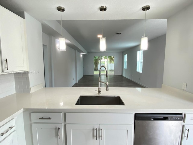 kitchen featuring white cabinetry, sink, stainless steel dishwasher, and decorative light fixtures