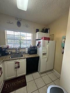 kitchen featuring dishwasher, white cabinets, sink, white fridge with ice dispenser, and light tile patterned flooring