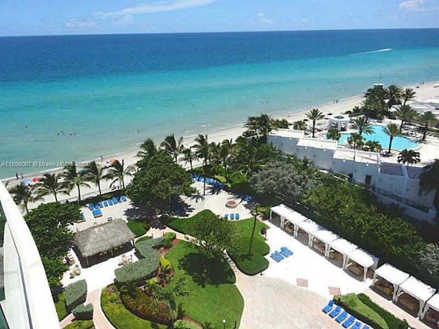 birds eye view of property with a water view and a beach view