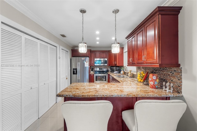 kitchen with pendant lighting, ornamental molding, light tile patterned flooring, kitchen peninsula, and stainless steel appliances