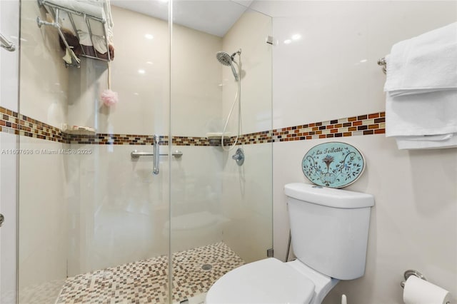 bathroom with an enclosed shower and toilet