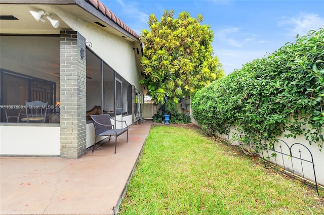 view of yard featuring a sunroom and a patio