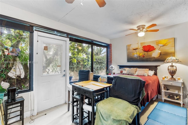 bedroom featuring ceiling fan, access to exterior, and a textured ceiling