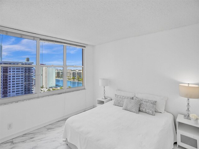 bedroom featuring a textured ceiling and a water view