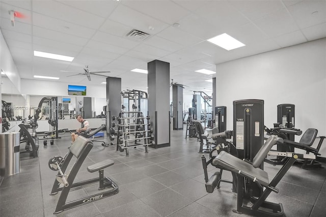 workout area with a paneled ceiling and ceiling fan