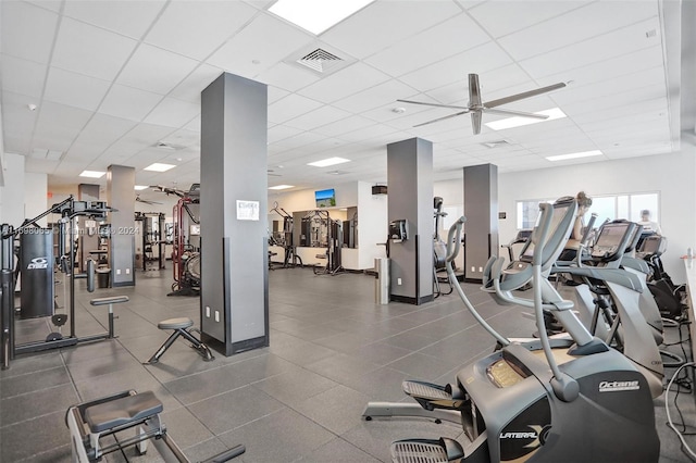 gym featuring a drop ceiling and ceiling fan