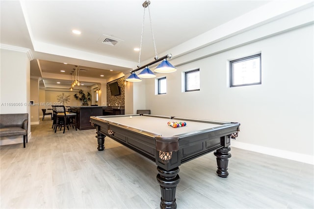 rec room with bar area, a tray ceiling, pool table, and light hardwood / wood-style flooring