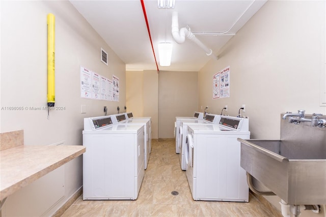 laundry area with separate washer and dryer and sink