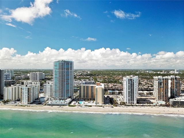 birds eye view of property featuring a water view and a beach view