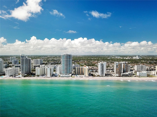 birds eye view of property with a water view and a beach view